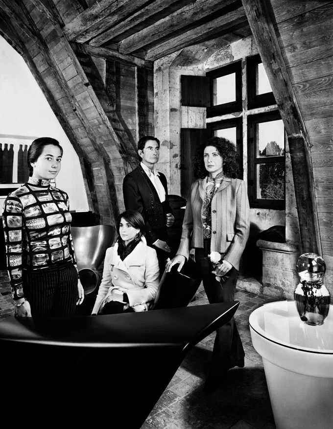 Portrait de famille de 4 personnes, en noir et blanc. Ils sont dans un salon, trois se tiennent debout et une est assise.